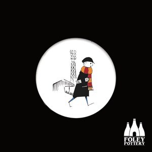 Puede incluir: Una ilustración en blanco y negro de una persona que lleva un abrigo negro y una bufanda roja y naranja caminando junto a un edificio con una torre alta. La ilustración está sobre un fondo blanco.