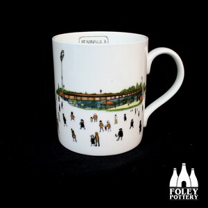 May include: White ceramic mug with a black and white illustration of a building and people. The text "PENINSULA" is printed on the mug.