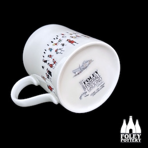 May include: White ceramic mug with a black and white illustration of people walking towards a stadium. The bottom of the mug has a black and white illustration of the Foley Football Ground in Stoke-on-Trent, Staffordshire.