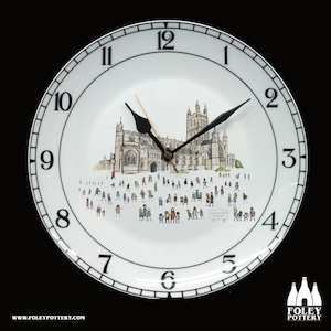 Puede incluir: Un plato de cerámica blanco con números y manecillas negros. La esfera del reloj presenta una ilustración en blanco y negro de una catedral con gente caminando frente a ella. El texto "GLOUCESTER CATHEDRAL" es visible en el plato.