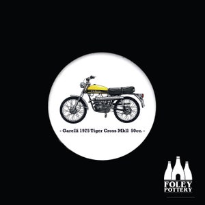 Pu&ograve; includere: Una moto Garelli Tiger Cross MkII 50cc del 1975, gialla e nera. La moto &egrave; su uno sfondo bianco.