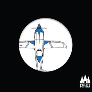 May include: A blue and white airplane with a red accent on the wing, viewed from above. The airplane has a single propeller and a clear cockpit.