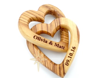 May include: Two interlocking wooden hearts with the names Olivia & Matt and the date 09.10.16 engraved on them.