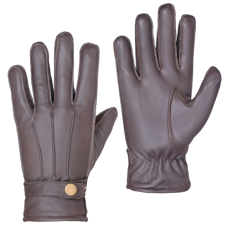 May include: A pair of brown leather gloves with a button detail on the wrist.