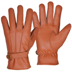 May include: A pair of brown leather gloves with a strap and button on one glove. The gloves have a stitched design on the back of the hand.
