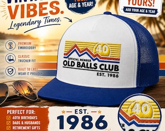 May include: A blue and white trucker hat with the text "OLD BALLS CLUB EST. 1986" and a graphic of a mountain range and the number 40. The hat has a mesh back and a curved brim. The text "VINTAGE VIBES" is also visible.