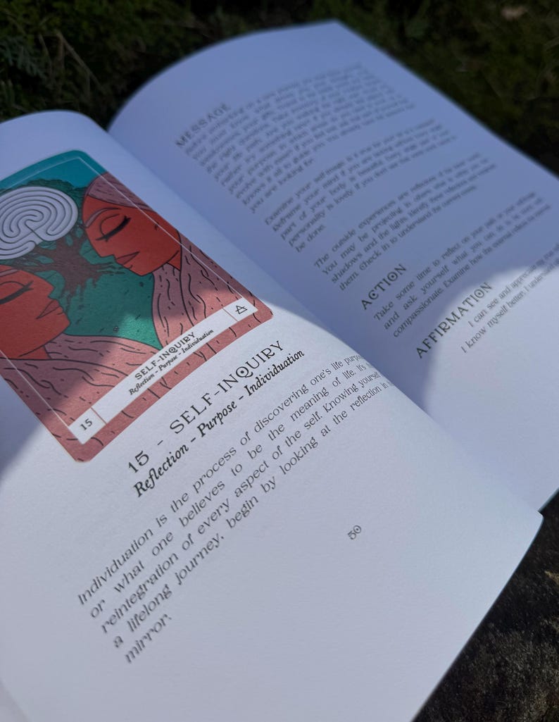 May include: An open book with a tarot card featuring two figures with red skin and a green background. The card reads "SELF-INQUIRY" and the page text discusses individuation and self-reflection.
