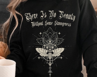 May include: A black long-sleeve sweatshirt featuring a white graphic print. The text reads "There Is No Beauty Without Some Strangeness" above a moth illustration centered within geometric shapes and the name "EDGAR ALLAN POE" at the bottom.