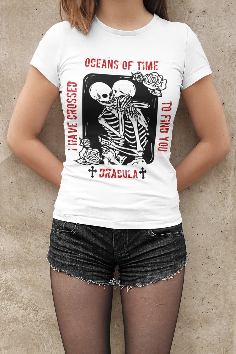 May include: White t-shirt with a black and white graphic of two skeletons embracing. The text "I have crossed oceans of time to find you" and "Dracula" are printed in red on the shirt.