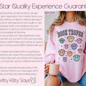 May include: Light pink sweatshirt with the text "BOOK TROPES" and various smiley face graphics. The sweatshirt also features text such as "Forbidden Love" and "Enemies to Lovers". The text "Witty Kitty Says" is also visible.