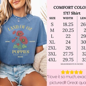May include: Blue jean-colored t-shirt with a graphic of red poppies and the text "Land of Oz Poppies." The shirt has a crew neck and short sleeves. Measurements are listed in inches.
