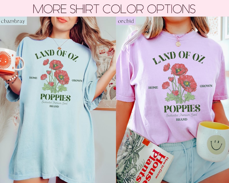 May include: Two t-shirts, one light blue and one orchid, with the text "LAND OF OZ" and a graphic of red poppies. The shirts also feature the words "HOME" and "GROWN" and the word "POPPIES". The text "Enchanted Premium Seed BRAND" is also visible.