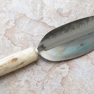 May include: A wooden handled stainless steel apple peeler with the word "SPUYEN" printed on the blade.