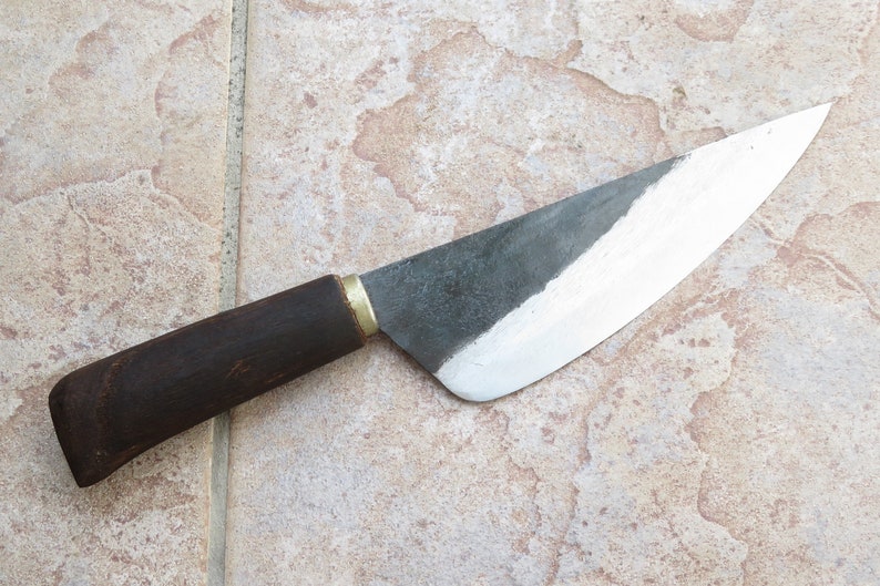 Puede incluir: Un cuchillo con mango de madera marr&oacute;n oscuro y hoja plateada. La hoja es ligeramente curva y tiene una punta afilada.