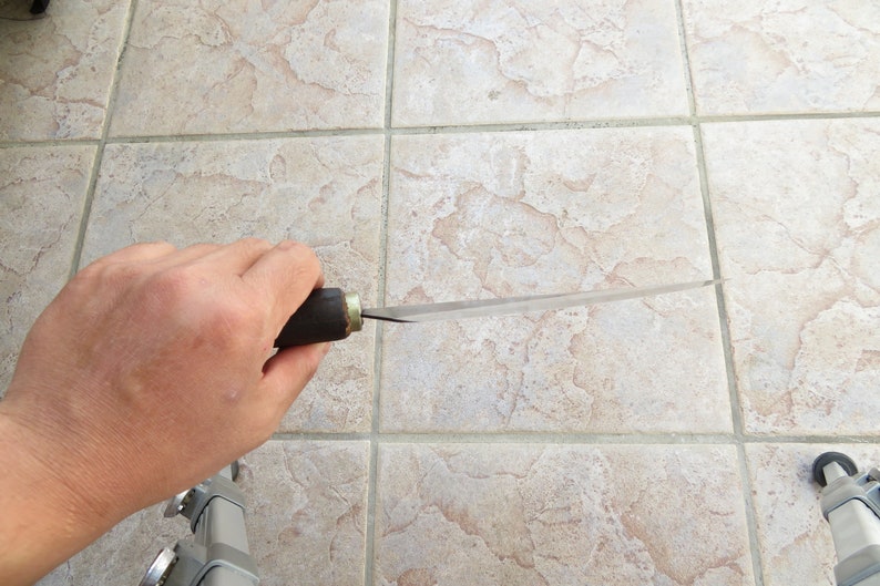 Puede incluir: Una persona sosteniendo un cuchillo largo, delgado y plateado con un mango de madera. El cuchillo es afilado y puntiagudo.