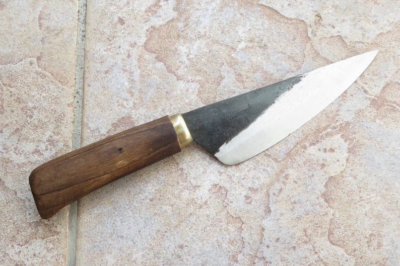 May include: A small, black-handled knife with a wooden handle and a brass accent. The blade is sharp and has a slight curve.