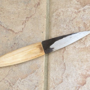 May include: A small, wooden-handled knife with a dark metal blade. The blade is sharp and pointed, and the handle is smooth and polished.