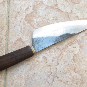 Puede incluir: Un cuchillo con mango de madera marr&oacute;n y hoja de plata. La hoja tiene una ligera curva y est&aacute; roma.