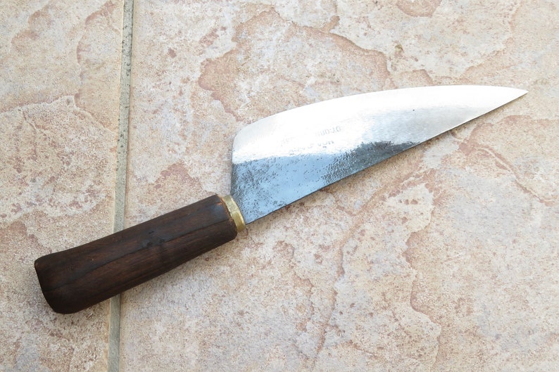 Puede incluir: Un cuchillo con mango de madera marr&oacute;n y hoja de plata. La hoja tiene una ligera curva y est&aacute; roma.