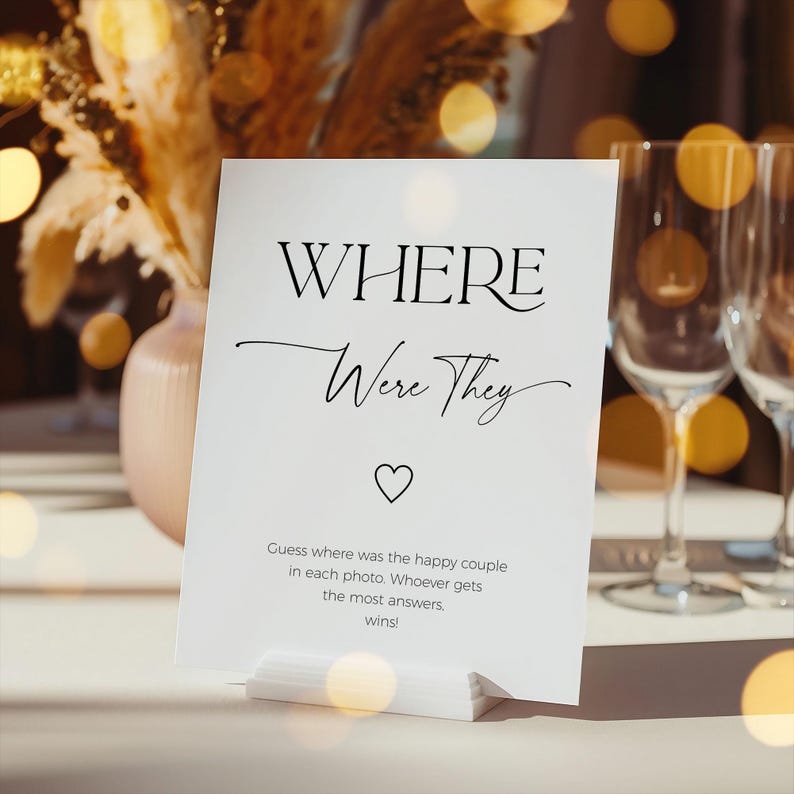 Where were they sign standing on a table with white table cloth and wine glasses in the background