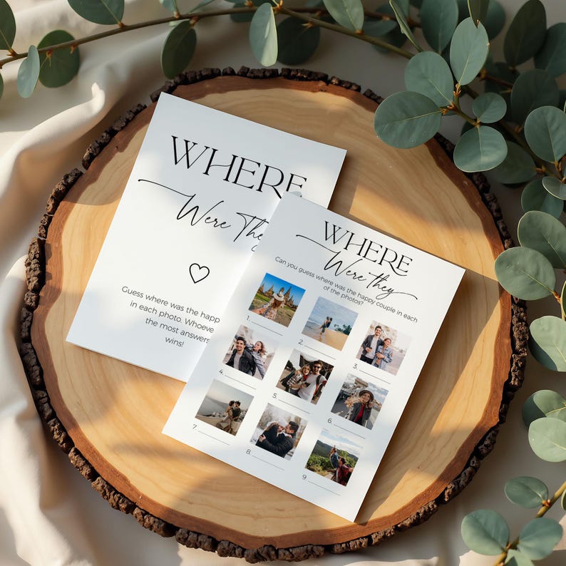Fun Bridal shower game "where were they" laying on  a round wooden board with eucalyptus branches around