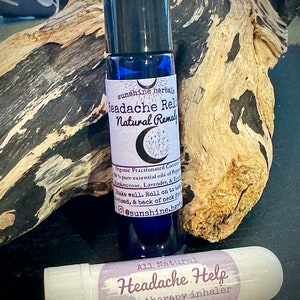 Puede incluir: Dos productos para aliviar el dolor de cabeza: un frasco azul de roll-on etiquetado como "Headache Relief Natural Remedy" y un inhalador de aromaterapia blanco etiquetado como "All Natural Headache Help aromatherapy inhaler".