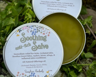 Op de afbeelding: Twee ronde zilveren metalen blikjes met een groene zalf. De etiketten zijn voorzien van bloemillustraties en de tekst: Soothing anti-itch Salve, Immediate relief for itchy, irritated skin, All Natural Offerings of: Chickweed, Plantain, Yarrow, EVOO, Vitamin E Oil, Beeswax, Sunshine Herbals, 2 oz.