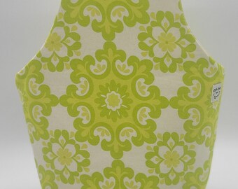 May include: A fabric tote bag with a lime green and cream floral pattern. The bag has a structured shape with a handle at the top. The floral design is a repeating pattern of stylized flowers and leaves.