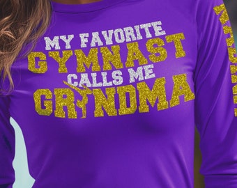 May include: Purple long-sleeved shirt with gold glitter text that reads "My Favorite Gymnast Calls Me Grandma".