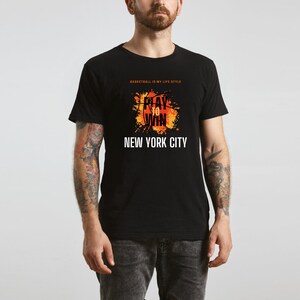Może przedstawiać: Czarny T-shirt z pomarańczowo-ż&oacute;łtym nadrukiem koszyk&oacute;wki i tekstem "Play to Win" oraz "New York City". Na koszulce znajduje się r&oacute;wnież napis "Basketball is my life style".
