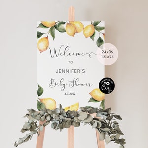 May include: A white welcome sign with a lemon theme. The sign reads "Welcome to Jennifer's Baby Shower 3.3.2022".