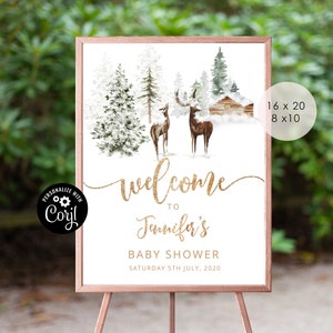 May include: Welcome sign for a baby shower with a winter woodland theme. The sign features a gold glitter font, a watercolor illustration of a snowy forest with two deer, and a small cabin. The text on the sign reads "Welcome to Jennifer's Baby Shower Saturday 5th July, 2020".