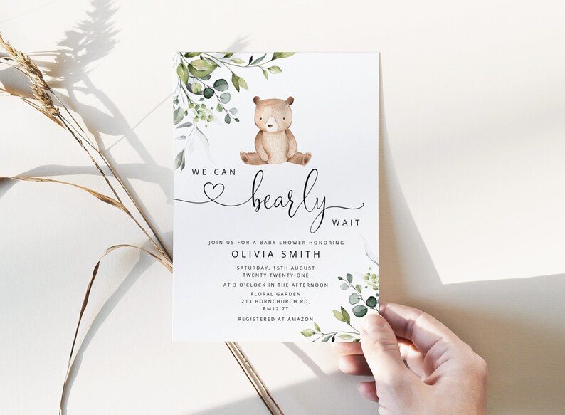 May include: A baby shower invitation with a cute cartoon bear and green foliage. The invitation reads "We can barely wait" and includes details for the event, including the date, time, and location. The event is for Olivia Smith.