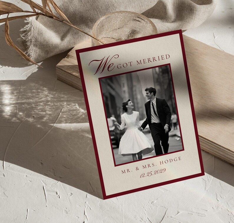 May include: A wedding announcement card with a claret border and the words "We Got Married" in elegant script. The card features a black and white photo of a couple and the text "Mr. & Mrs. Hodge 12.25.2029".