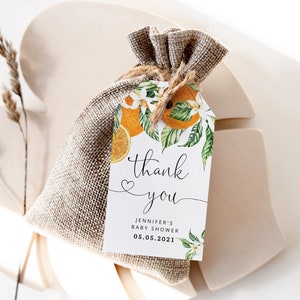 May include: A white thank you tag with orange blossoms and fruit, with the text "thank you" and "Jennifer's Baby Shower 05.05.2021".