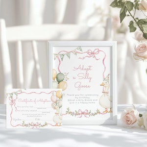 May include: A framed print and certificate with a watercolor design. The print reads "Adopt a Silly Goose" with a goose illustration. The certificate has space for adoption details. Soft pink and green accents decorate the design.