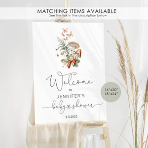 May include: Welcome to Jennifer's baby shower sign with a mushroom, fern, and butterfly illustration. The sign is white with black text and is available in 16"x20" or 18"x24" sizes.
