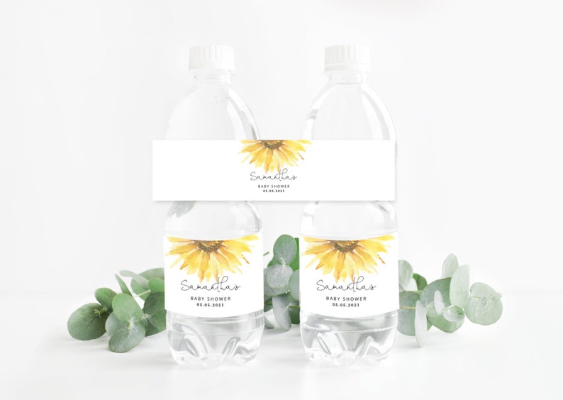 May include: Two clear plastic water bottles with white labels featuring a watercolor sunflower design. The labels have the text "Samantha's Baby Shower 05.06.2023".