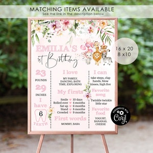 Op de afbeelding: Een roze en groene bloemen eerste verjaardagsbord met een jungledieren thema. Het bord bevat de naam "Emilia's 1st Birthday" en details over de groei van de baby, inclusief gewicht, lengte, eerste keer en favoriete dingen. Het bord is verkrijgbaar in twee maten: 16x20 en 8x10 inch.
