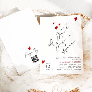 May include: White bridal shower invitation with red heart accents. The invitation reads "A Match Made in Heaven" and includes event details. A matching registry card with a QR code is also visible.