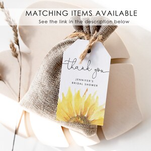 May include: A white thank you tag with a watercolor sunflower design. The tag says "thank you" in cursive and "Jennifer's Bridal Shower".