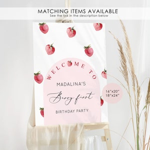 May include: Welcome to Madalina's Berry First Birthday Party sign with a pink and white background and strawberry illustrations. The sign is available in 16"x20" and 18"x24" sizes.