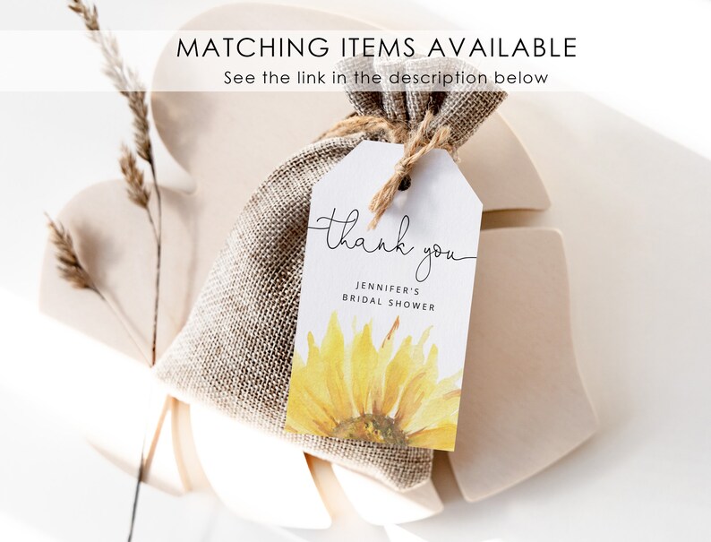 May include: A white thank you tag with a watercolor sunflower design. The tag says "thank you" in cursive and "Jennifer's Bridal Shower".