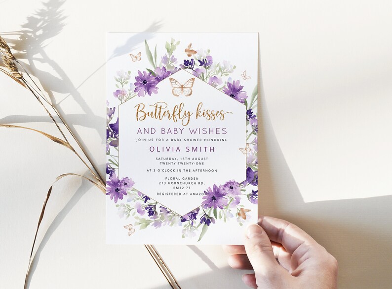 Może przedstawiać: Fioletowe i złote zaproszenie na baby shower z kwiatowym wzorem i motylami. Zaproszenie zawiera napis "Butterfly kisses and baby wishes" oraz imię Olivia Smith, datę, godzinę i miejsce imprezy.