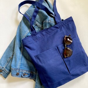 Multi pocket indigo blue school bag with zipper closure. Medium tote with spacious inside for books, laptop, folders and personal essentials. Women bag is made with durable cotton canvas fabric.