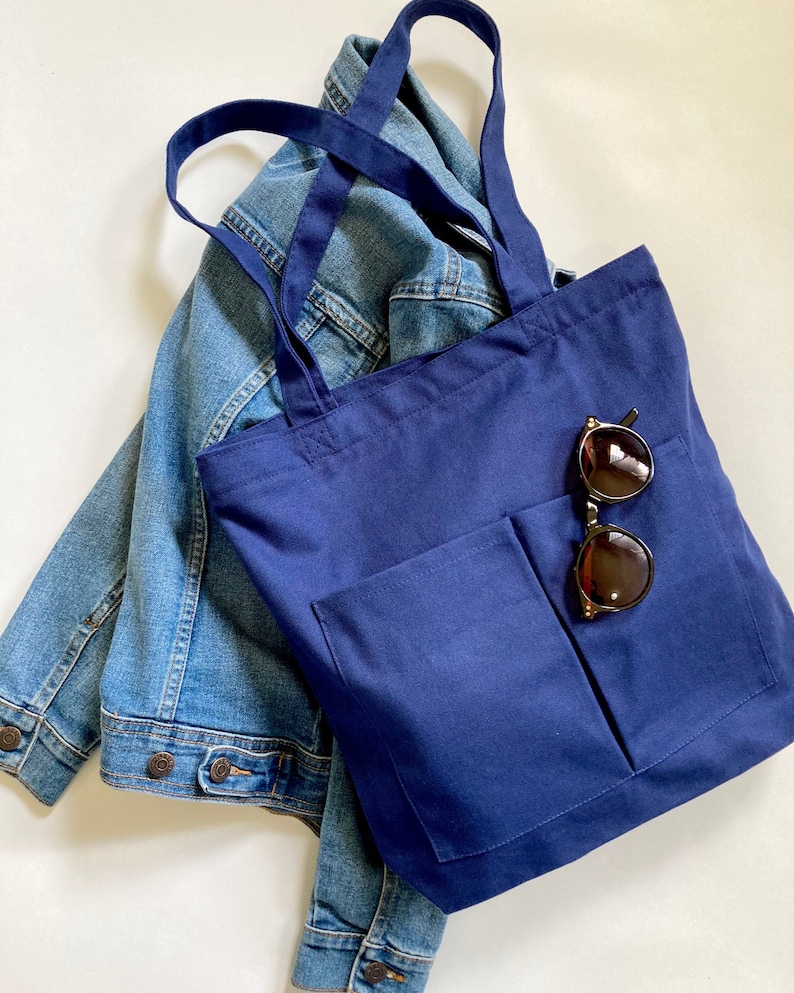 Multi pocket indigo blue school bag with zipper closure. Medium tote with spacious inside for books, laptop, folders and personal essentials. Women bag is made with durable cotton canvas fabric.