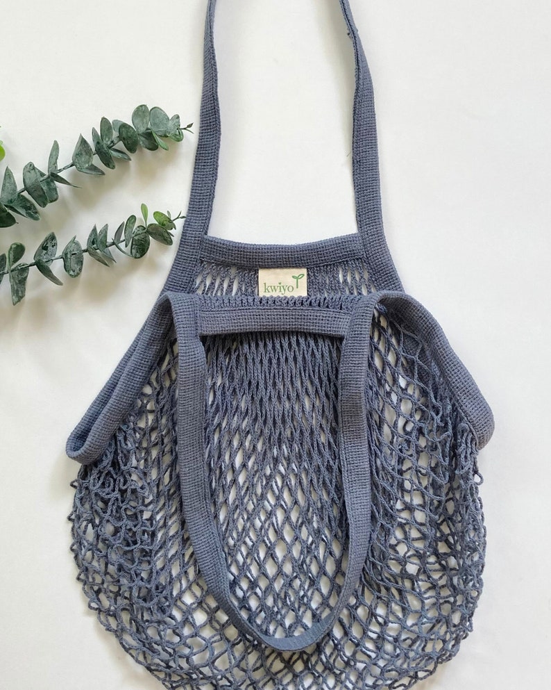 A gray cotton mesh bag with thick cotton straps. The bag is made with natural cotton and heavy duty mesh netting.
