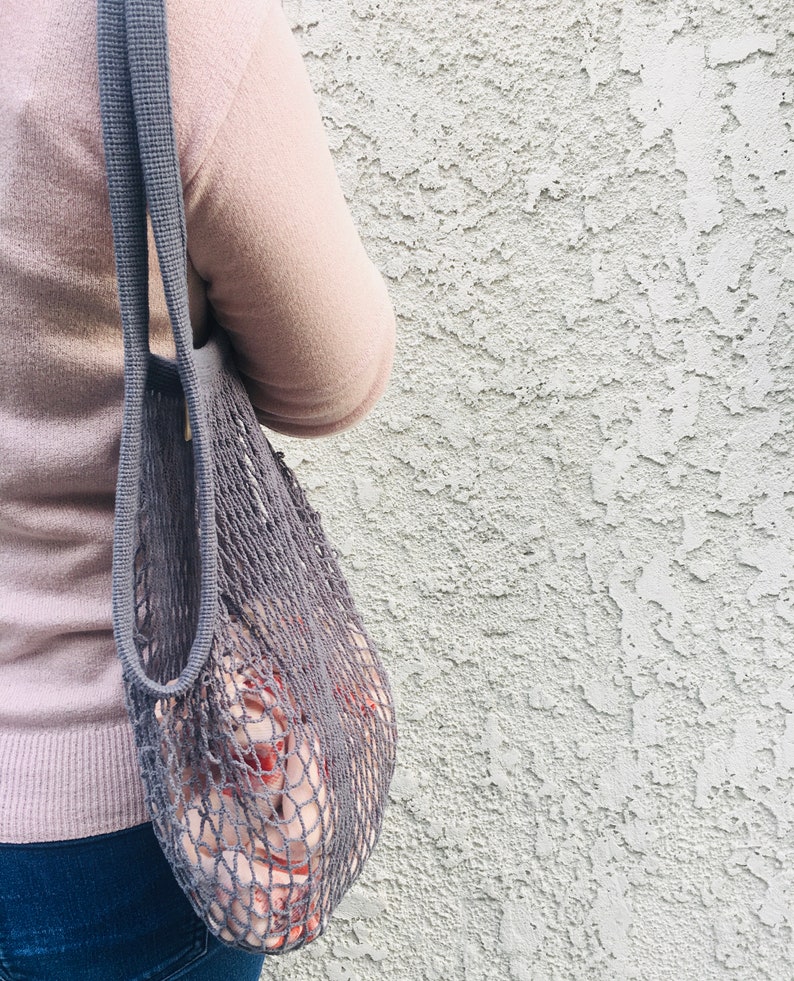 woman with a gray mesh bag on her shoulder