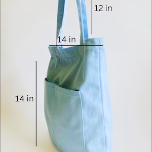 light blue medium shopping tote bag with multiple pockets and zipper showing 12 inches straps, 14 inches width, 14 inches height and 3 inches bottom