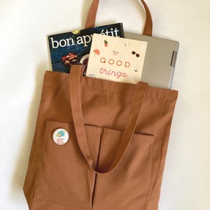 Zippered tote bag with pockets and long shoulder straps. Cotton canvas bag in terracota color for men and women.